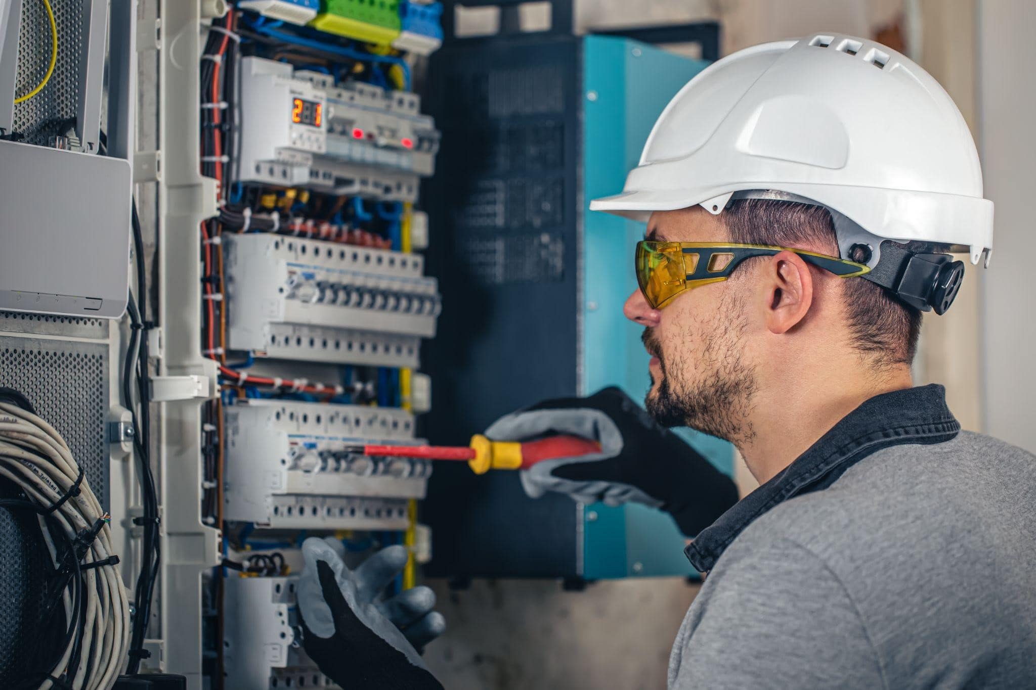 Image illustrating a professional electrician in New York, working in a switchboard with fuses