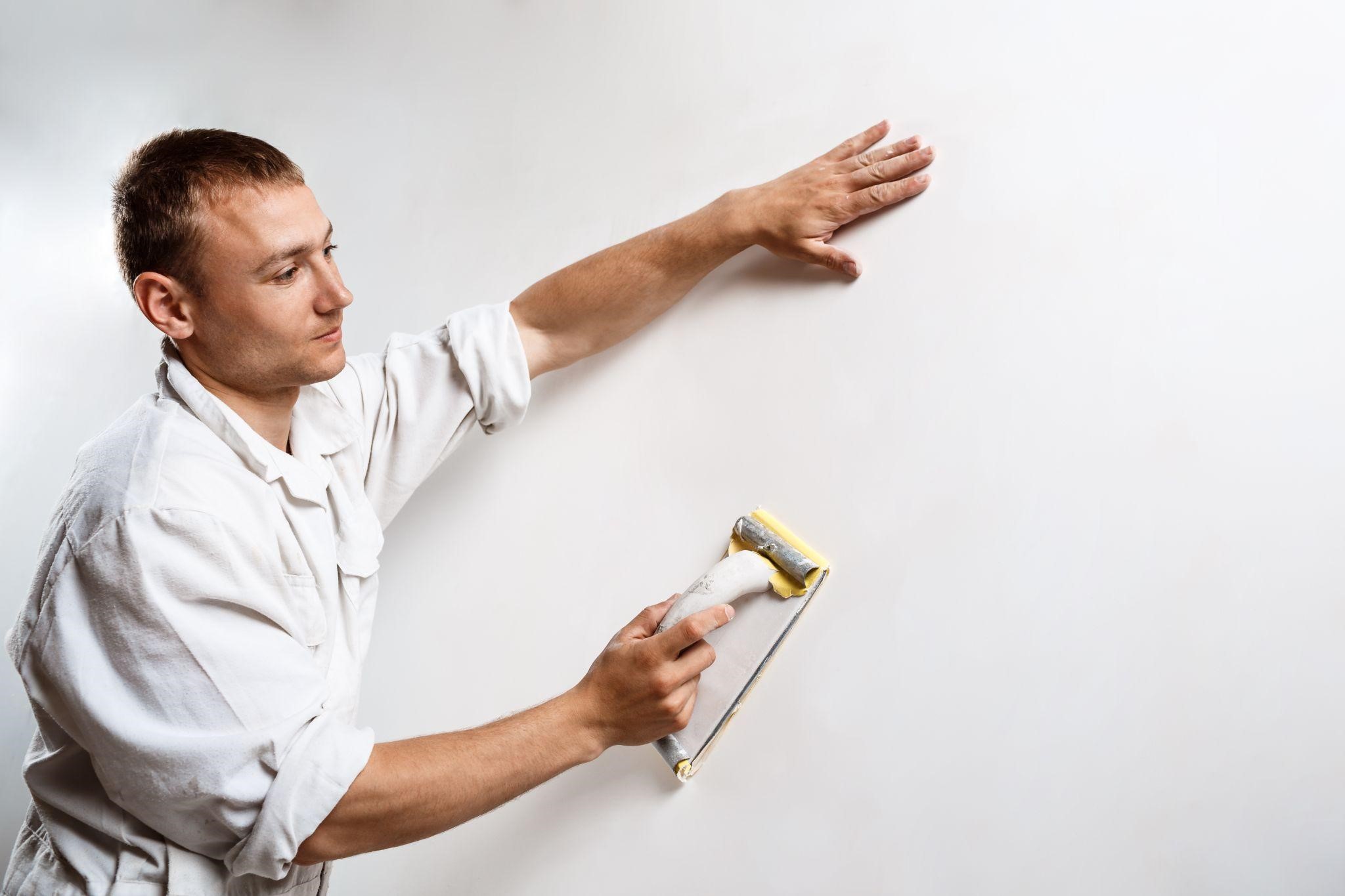Image illustrating a professional painter in New York grinding the wall with sandpaper