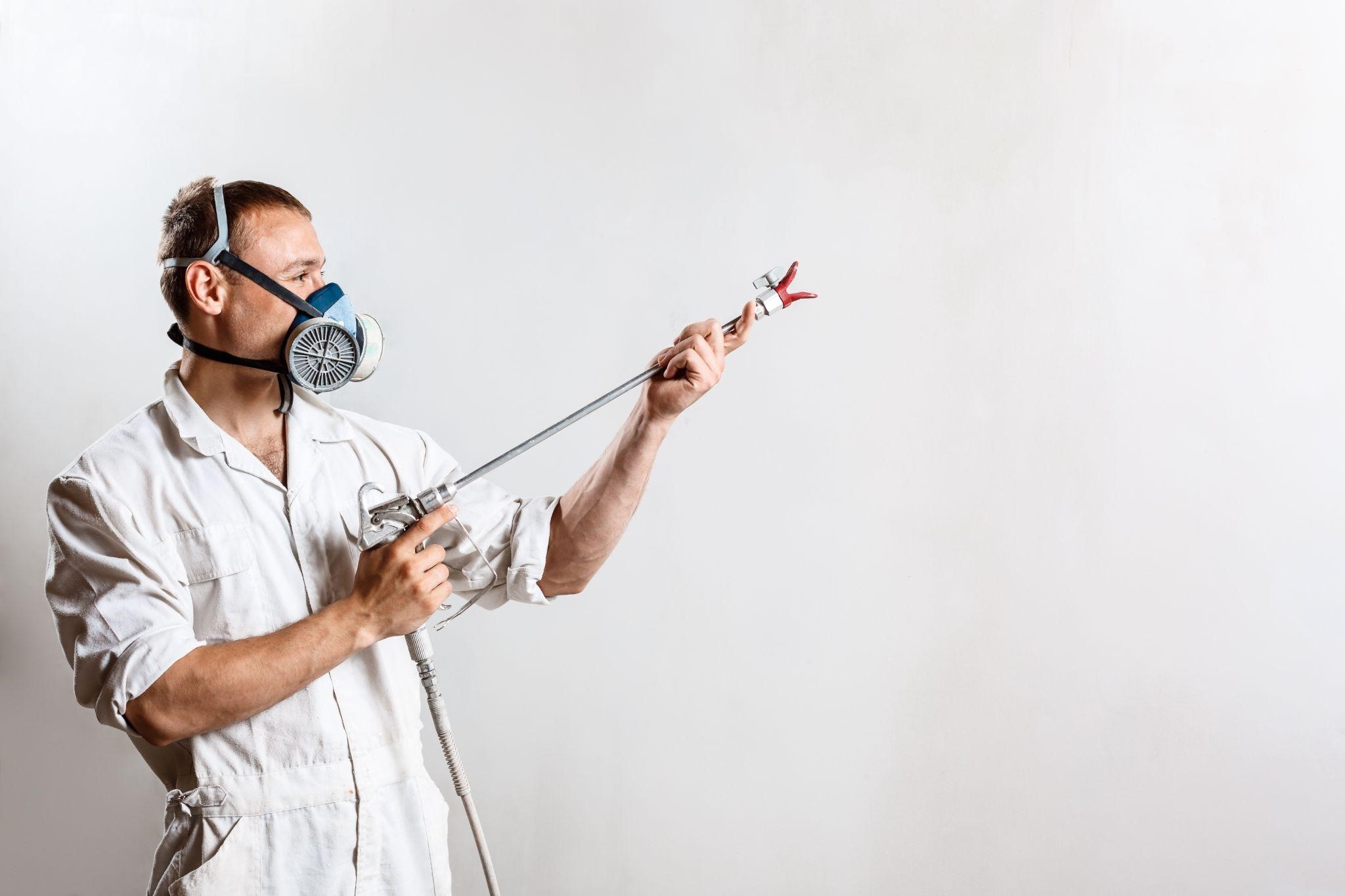 Image illustrating a worker painting wall with spray gun in New York